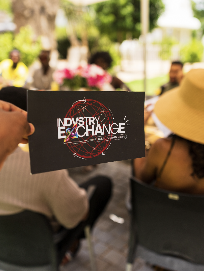Indvstry Exchange card held at an outdoor gathering